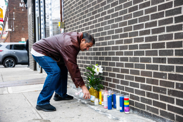 뉴욕 브루클린 총격 현장에서 한 시민이 희생된 7개월 아기를 추모하며 촛불을 밝히고 있다. AFP=연합뉴스