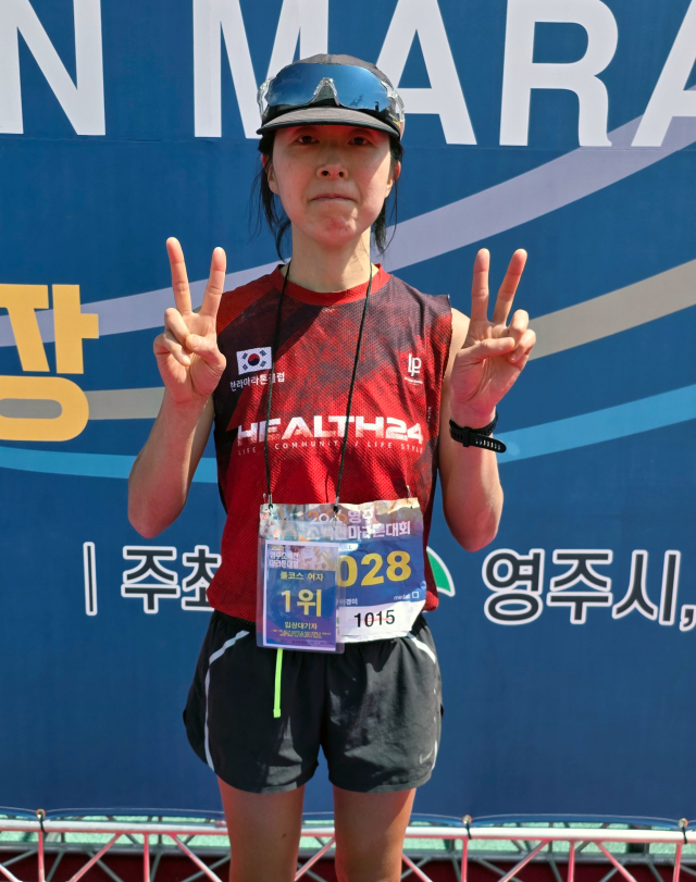 2026 영주소백산마라톤대회 여자 풀코스 부문 1위를 차지한 문이경미 씨가 단상에서 손가락으로 V를 만들며 기념 촬영하고 있다. 김영진 기자
