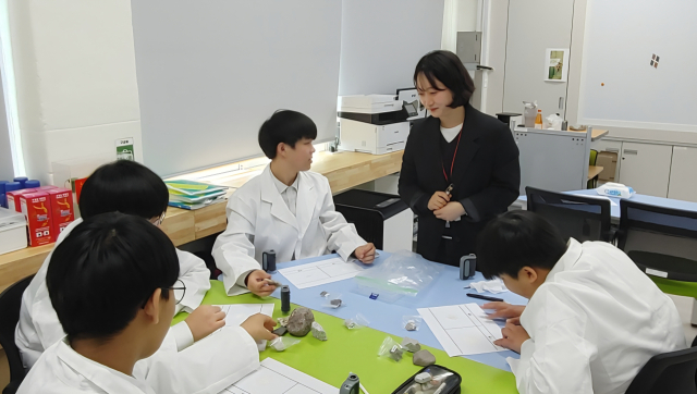 청송군 세계지질공원 담당자(검은 옷)가 청송중학교 학생들에게 암석을 구분하는 방법을 설명하고 있다. 청송교육지원청 제공