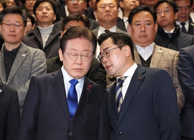 2024년 12월 14일 이재명 더불어민주당 대표와 박찬대 원내대표가 윤석열 대통령 탄핵소추안이 가결된 뒤 국회 본회의장을 나와 인사를 하기 전 대화를 나누고 있다. 연합뉴스