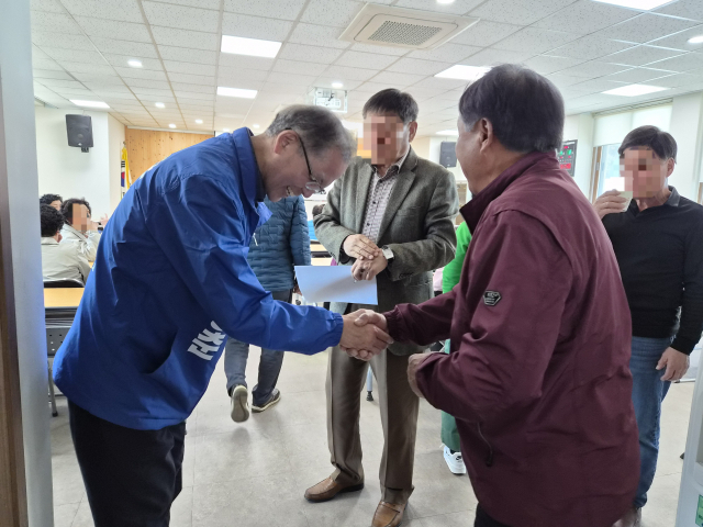 6·3 지방선거 예천군수 선거를 둘러싸고 국민의힘은 후보 선출 방식도 정하지 못하고 있지만 더불어민주당은 윤동춘 전 경북경찰청장을 일찌감치 후보로 결정했다. 사진은 윤 전 청장이 유권자들을 만나 악수를 나누고 있는 모습. 독자 제공