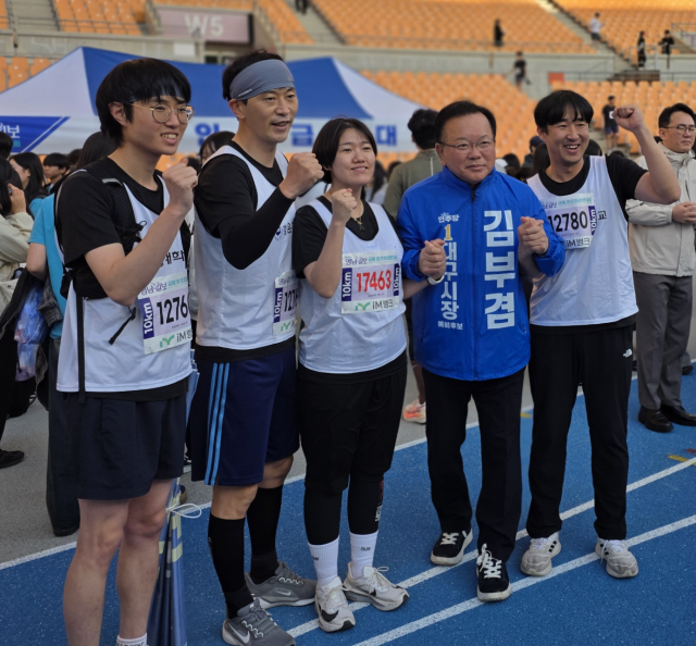 12일 오전 대구스타디움에서 열린 영남일보 국제하프마라톤대회에서 김부겸 더불어민주당 대구시장 예비후보가 대회 참가자들과 기념촬영하고 있다. 