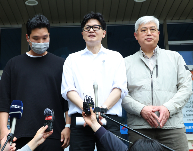 한동훈 전 국민의힘 대표가 14일 오후 부산 북구 만덕2동 행정복지센터를 찾아 전입신고를 마친 뒤 이웃 주민과 함께 소감을 말하고 있다. 한 전 대표는 이곳으로 전입신고를 하며 전재수 의원의 부산시장 출마로 보궐선거 진행될 예정인 부산 북구갑 출마를 공식화했다. 연합뉴스