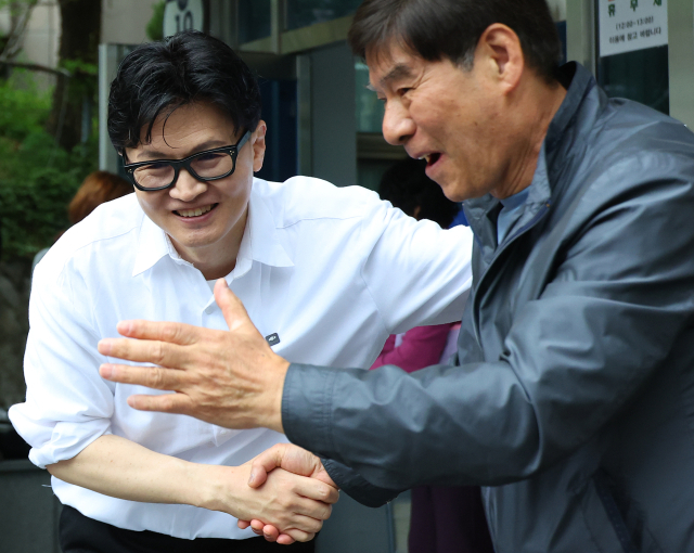 한동훈 전 국민의힘 대표가 14일 오후 부산 북구 만덕2동 행정복지센터를 찾아 전입신고를 마친 뒤 주민들과 사진을 찍고 있다. 한 전 대표는 이곳으로 전입신고를 하며 전재수 의원의 부산시장 출마로 보궐선거 진행될 예정인 부산 북구갑 출마를 공식화했다. 연합뉴스