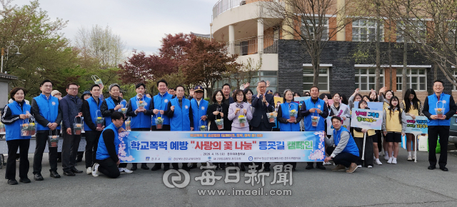 15일 경주여중에서 법무부 청소년 범죄예방위원 경주지역협의회 주관으로 학교폭력예방 꽃 화분 선물 등굣길 캠페인을 벌인 후 관계자들이 기념사진을 촬영하고 있다. 경주범방 제공