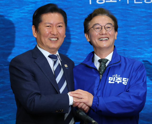 더불어민주당 정청래 대표가 15일 오전 부산 동구 부산항국제전시컨벤션센터에서 열린 부산 현장 최고위원회에서 전재수 부산시장 후보와 손을 맞잡고 있다. 연합뉴스