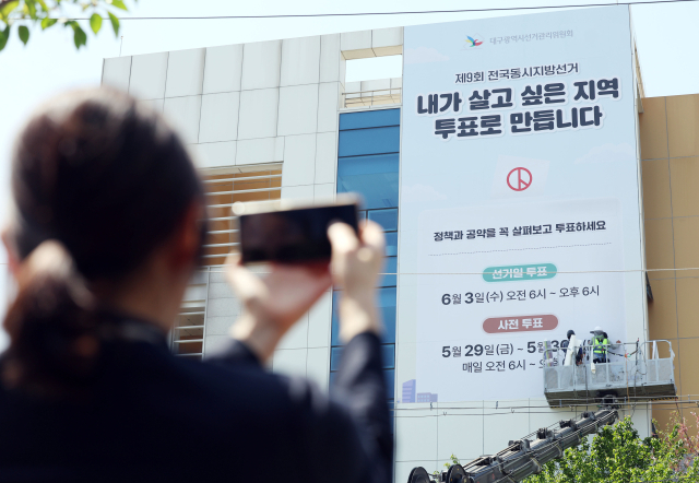 15일 오후 대구 서구 대구시선관위 건물 외벽에 제9회 전국동시지방선거의 투표를 독려하는 대형 홍보물이 설치되고 있다. 연합뉴스