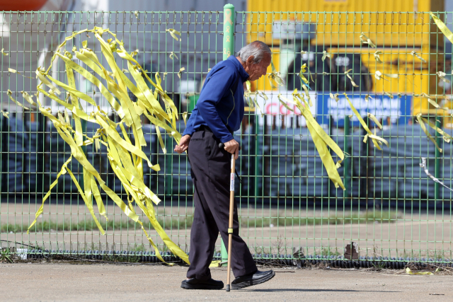 세월호 참사 12주기인 16일 전남 목포신항에 한 추모객이 철조망에 걸린 노란 리본을 둘러보고 있다. 연합뉴스