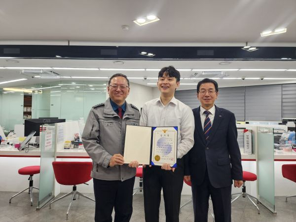 부산 금정경찰서 신경범 서장(왼쪽)이 보이스피싱 피해를 예방한 부산은행 금사공단지점 직원에게 감사장을 전달한 뒤 기념촬영을 하고 있다. [사진=부산금정경찰서]