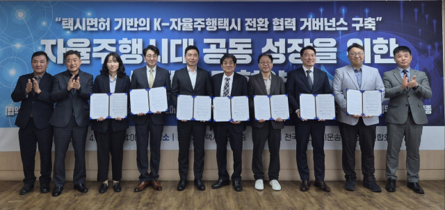 지난 13일 택시면허 기반의 K 자율주행택시 전환 현력 거버넌스 구축 업무협약식 체결 후 참석자들이 기념촬영을 하고 있다. 오토노머스에이투지 제공