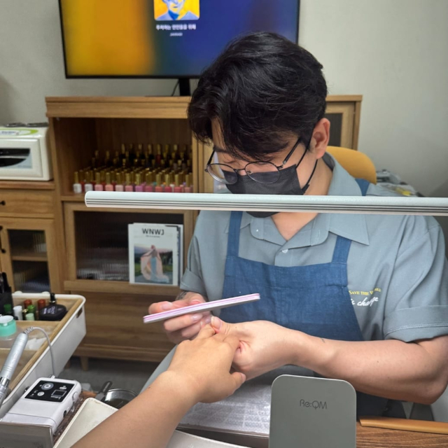 남성 네일아티스트 손기환 씨가 여성 고객의 네일을 손질하고 있다. 성별에 따라 나뉘던 직업의 경계를 넘어, 