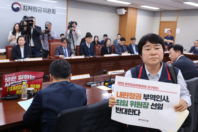 21일 세종시 정부세종청사 최저임금위원회에서 열린 내년도 최저임금을 정하기 위한 첫 전원회의에서 근로자위원인 이미선 민주노총 부위원장이 권순원 위원장 선출에 반대하며 퇴장하고 있다. 연합뉴스