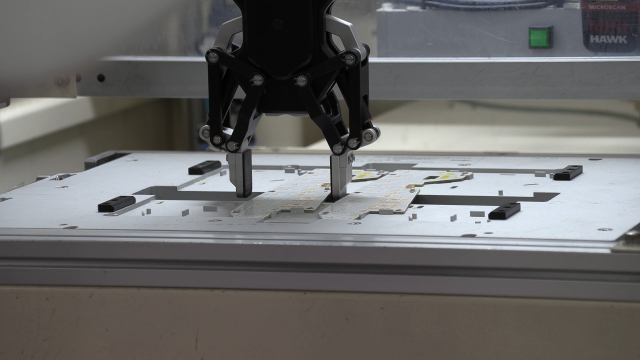 지난 24일 에스엘 성서전자공장에서 이동형 양팔로봇이 집게 손을 이용해 램프용 회로기판(PCB)를 가공 기계에 안착시키는 모습. 대구기계부품연구원 제공