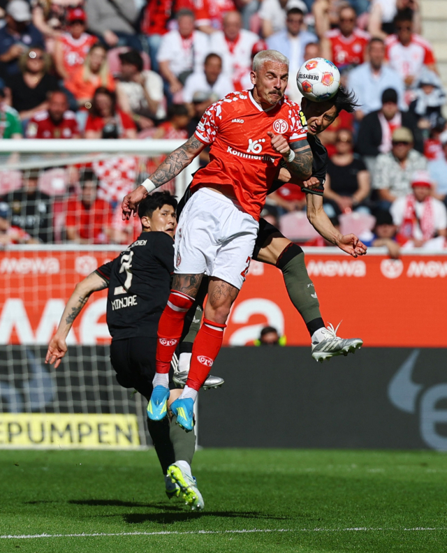 바이에른 뮌헨의 센터백 듀오 김민재와 이토 히로키가 25일 독일 마인츠의 메바 아레나에서 열린 분데스리가 31라운드 경기 도중 마인츠의 필립 티에츠와 공중볼 경합을 벌이고 있다. 로이터 연합뉴스
