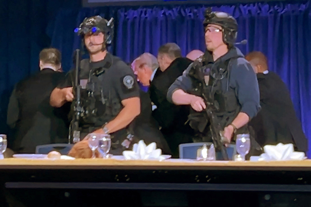 25일(현지시간) 미국 워싱턴 DC 힐튼호텔에서 열린 만찬 행사 도중 총성이 들리자 도널드 트럼프 미국 대통령이 경호 인력의 호위를 받으며 현장을 빠져나가고 있다. 로이터 연합뉴스