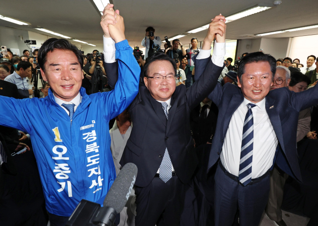 26일 오후 대구 달서구 두류역 인근에 마련된 더불어민주당 김부겸 대구시장 예비후보의 희망캠프 선거사무소 개소식에서 왼쪽부터 오중기 경북도지사 예비후보와 김 예비후보, 정청래 대표가 손을 맞잡고 있다. 연합뉴스
