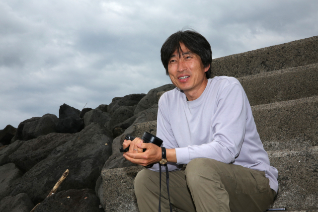 지난 23일 제주도 용머리 해안에서 만난 서민규 사진가가 출판사 마르시안스토리와 함께한 지난 20년의 이야기를 들려주고 있다. 김도훈 기자
