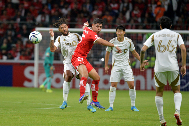 LAFC의 드니 부앙가(왼쪽)가 7일 멕시코 톨루카에서 열린 CONCACAF 챔피언스컵 준결승 2차전 도중 동료 손흥민이 지켜보는 가운데 톨루카의 에두아르도 로페즈와 공을 다투고 있다. AFP 연합뉴스