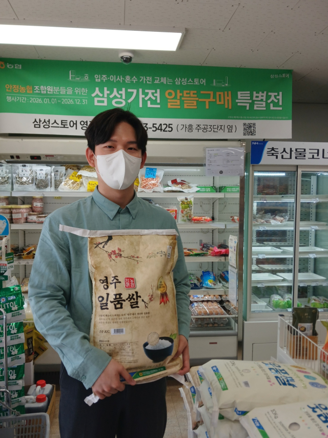 안정농협 직원이 영주일품쌀을 들어보이고 있다. 안정농협 제공