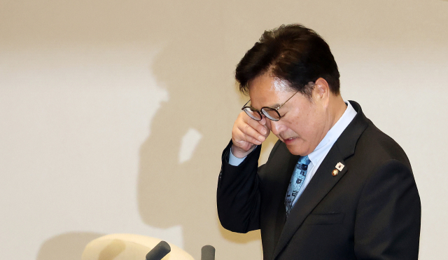 우원식 국회의장이 8일 국회에서 열린 제435회 국회(임시회) 2차 본회의에서 헌법 개정안 표결과 50개 법안 처리와 관련해 국민의힘의 필리버스터 신청으로 안건을 상정하지 않겠다고 밝히며 울분을 토한 뒤 눈물을 닦고 있다. 연합뉴스