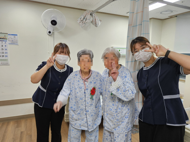 유리의료재단 경북도립안동노인전문병원 임직원들이 지난 8일 어버이날을 맞아 입원 환자들에게 카네이션을 달아 드리고 함께 웃으며 기념 촬영하고 있다. 유리의료재단 제공