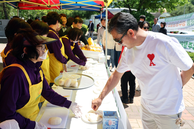 (사)한국후계농업경영인 성주군용암면회가 중부내륙고속도로 남성주참외휴게소에서 개최한 성주참외 시식회에서 여행객이 참외를 맛보고 있다. 성주군 제공