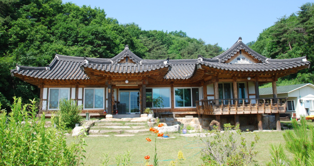 강원특별자치도 화천군 간동면 산자락에 위치한 화천 한옥학교. 산과 하늘, 꽃과 나무가 어우러져 우리나라 고유의 아름다움을 보여주고 있다.