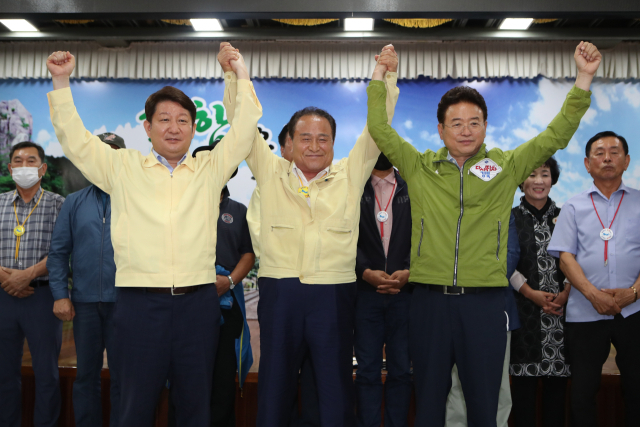 대구경북신공항 이전부지로 의성군 비안면, 군위군 소보면이 확정된 2020년 7월29일 권영진 당시 대구시장(사진 왼쪽)과 김영만 당시 군위군수, 이철우 경북도지사 등이 만세를 외치고 있다. 매일신문DB.