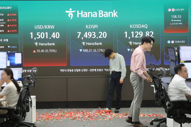 코스피가 장 초반 사상 처음 8,000선을 돌파한 뒤 급락 전환해 7,500선을 내준 15일 서울 중구 하나은행 딜링룸에서 직원이 8,000선 돌파기념 세리머니 흔적을 바라보고 있다. 연합뉴스