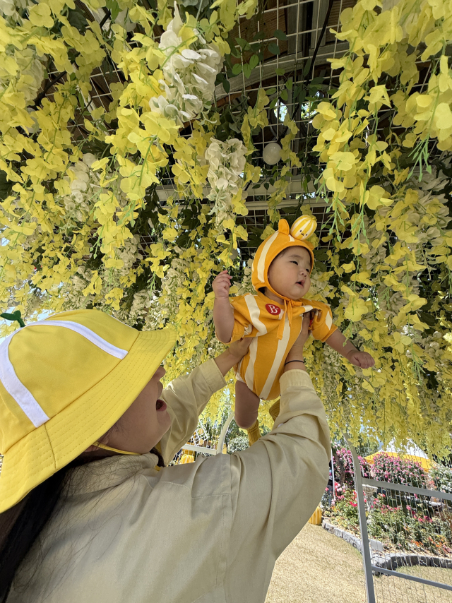 2026 성주참외&생명문화축제 참외힐링 공원에서 참외 복장을 한 아기와 엄마가 기념 사진을 찍고 있다. 독제 제공