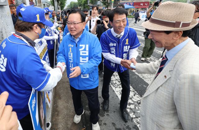 더불어민주당 박형룡 달성군 국회의원 보궐선거 후보가 21일 대구 달성군 화원시장을 찾아 더불어민주당 김부겸 대구시장 후보(왼쪽)와 함께 시민들에게 인사하고 있다. 연합뉴스