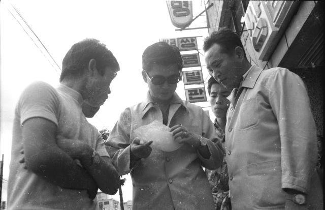 1972년 남북공동성명 호외를 보는 시민들. 매일DB