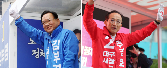 더불어민주당 김부겸 대구시장 후보(왼쪽)와 국민의힘 추경호 대구시장 후보가 21일 대구 범어네거리와 반월당사거리에서 출근길 인사를 하고 있다. 연합뉴스