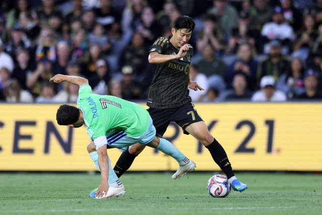 LAFC의 손흥민이 25일 미국 캘리포니아주 LA의 BMO 스타디움에서 열린 2026 MLS 15라운드 홈 경기 도중 드리블로 시애틀의 크리스티안 롤단을 제치고 있다. AFP 연합뉴스