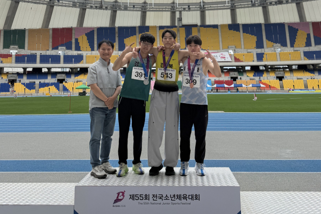 제55회 전국소년체육대회에서 이유건(오른쪽 두 번째·3학년) 학생이 멀리뛰기 종목에서 금메달을 차지한 뒤 김영철(맨 왼쪽) 교장 등과 기념촬영을 하고 있다. 순심중 제공
