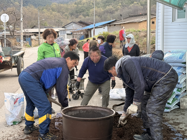 군위형 마을만들기 사업은 주민들이 직접 마을의 문제를 발굴, 해결하도록 역량을 강화하고, 마을의 자원을 활용한 축제나 전시회 등 다양한 문화 프로그램을 만드는 단계로 확대된다. 지난 2월 군위군 의흥면 매성2리 주민들이 힘을 모아 마을 화단 가꾸기를 하고 있다. 군위군 제공.