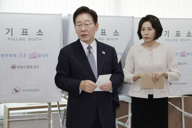 이재명 대통령이 제9회 전국동시지방선거 사전투표 첫날인 29일 서울 종로구 삼청동 주민센터에서 사전 투표 중 기표 도장 관련 문의를 하고 있다. 연합뉴스