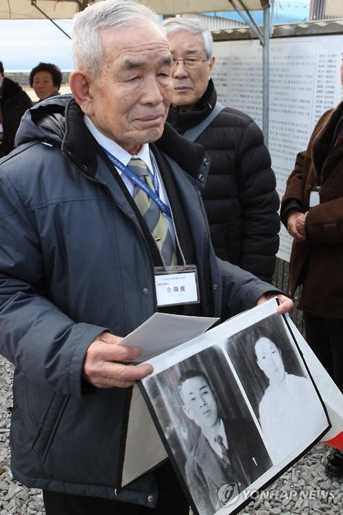 2016년 1월 일본 야마구치현 우베시에서 열린조세이탄광 수몰 사고 희생자 위령제에 유가족으로 참석한 전석호 씨가 부모님 사진을 들고있다. 연합뉴스