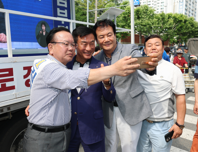 더불어민주당 김부겸 대구시장 후보가 1일 대구 달서구 이곡동 월요시장에서 유권자들과 사진을 찍고 있다. 안성완 기자 asw0727@imaeil.com