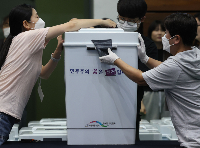 6·3지방선거일인 3일 서울 관악구 서울대학교 체육관에 마련된 개표소에서 개표사무원들이 사전투표함을 개함하고 있다. 연합뉴스