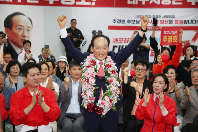 국민의힘 추경호 대구시장 후보가 당선이 유력시되면서 4일 오전 대구 범어네거리 선거사무소에서 축하 꽃다발을 목에 걸고 있다. 연합뉴스