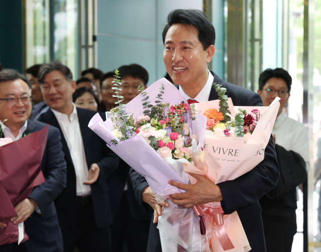 오세훈 서울시장이 4일 서울시청 로비에서 꽃다발을 받은 뒤 기뻐하고 있다. 연합뉴스