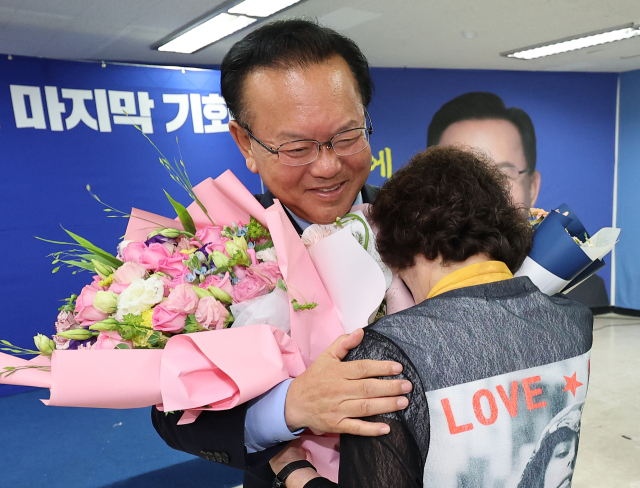 제9회 전국동시지방선거 대구시장 선거에서 낙선한 더불어민주당 김부겸 후보가 4일 대구 달서구 선거사무소에서 열린 캠프 해단식에서 지지자들에게 꽃다발을 받고 있다. 연합뉴스