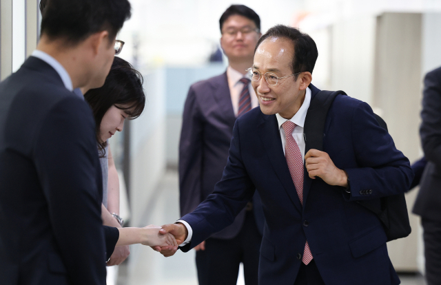 국민의힘 추경호 대구시장 당선인이 5일 대구 동구 신천동 대구정책연구원에서 김정기 대구시장 권한대행을 비롯한 대구시 관계자들에게 업무보고를 받기 위해 이동하며 직원들과 악수하고 있다. 연합뉴스