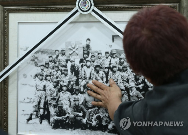 실미도에서 훈련을 받은 공작원들의 사진. 사진 앞에서 유족들이 오열하고 있다. 연합뉴스 제공.
