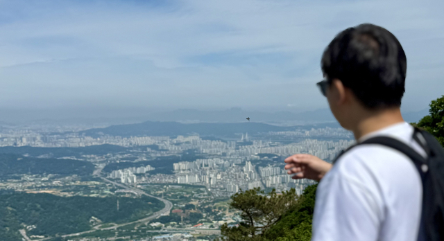 경기도 하남시 검단산 정상에서 한 남성이 서울 강동구와 광진구 일대 아파트 단지를 바라보는 모습. 2026.6.6. 홍준표 기자