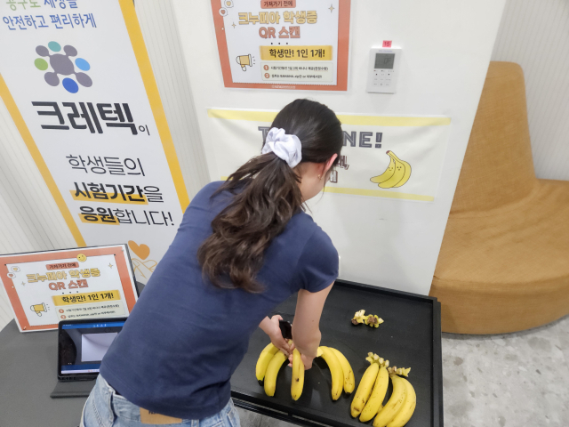 한 경북대 학생이 바나나집 안에서 QR코드로 학생 인증을 마친 후 바나나 하나를 집어 들고 있다. 윤정훈 기자
