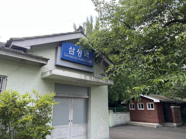 우거진 나무 그늘 밑에 이제는 문이 닫힌 삼성역이 서 있다. 정두나 기자.