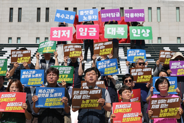 양대노총 조합원들이 15일 서울 종로구 세종문화회관 앞에서 2027년 적용 최저임금 노동계 요구안 발표 기자회견을 하고 있다. 연합뉴스