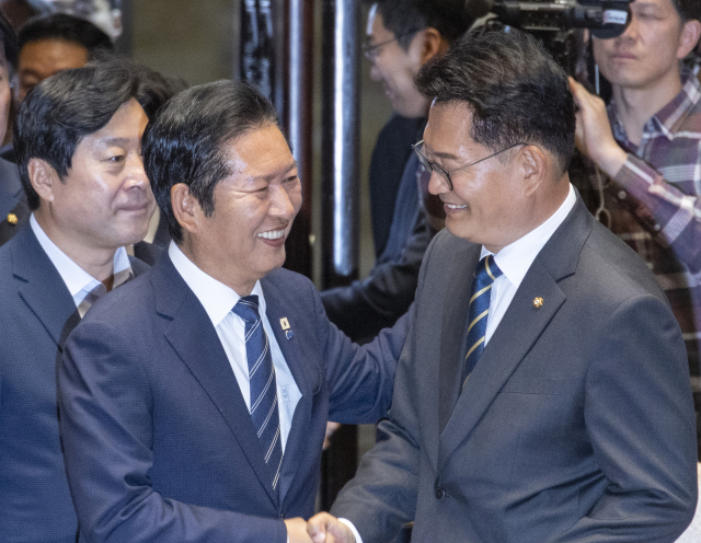 더불어민주당 정청래 대표(왼쪽)가 11일 국회에서 열린 의원총회에 입장하다 송영길 의원과 악수하고 있다. 연합뉴스